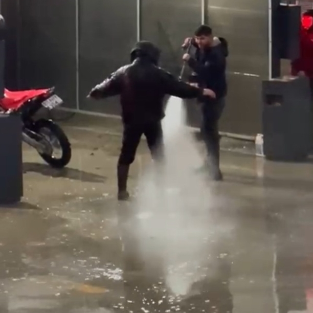 Çamurlu araziden dönen motosiklet sürücüsü, basınçlı suyla temizlendi