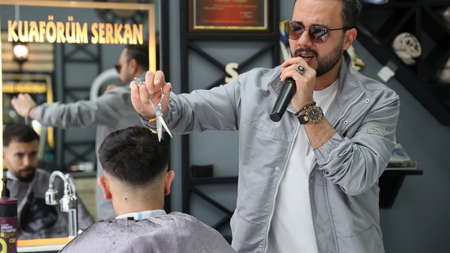 Bir elinde makas diğer elinde mikrofon
Kuaför dükkanında hem tıraş hem konser hizmeti sunuyor