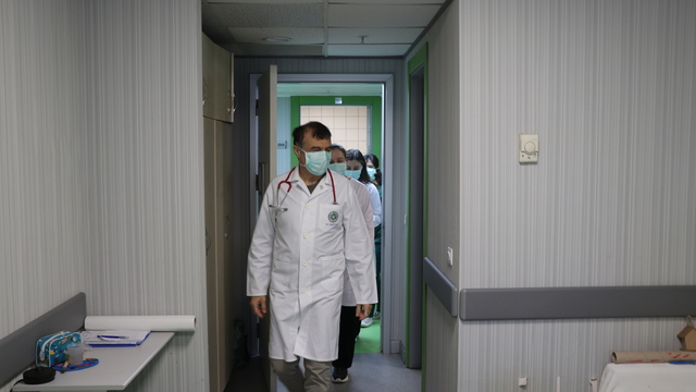 Doktor önlüğüyle hastanede, mikrofon başında radyoda