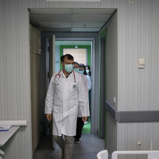 Doktor önlüğüyle hastanede, mikrofon başında radyoda