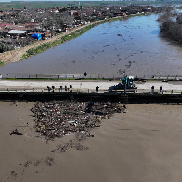 Edirne'de suyun sürüklediği ağaç gövdeleri ve çöplerle tıkanan köprü gözler...