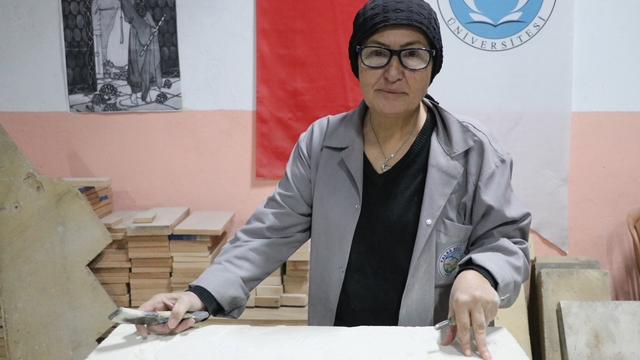 Hat sanatı hocası, tarihi Rum Yetimhanesi'nin bahçesinde kurulan atölyede taşa şekil veriyor