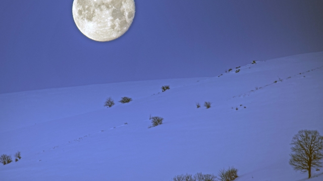 Karlı dağlar ile dolunay aynı karede güzel görüntüler oluşturdu