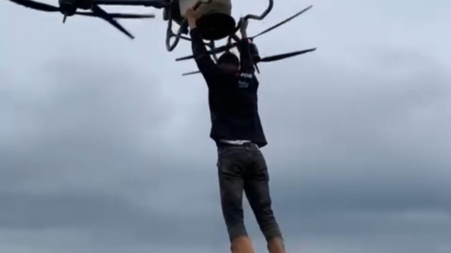 Çiftçi, drona tutunarak tarlanın diğer tarafına geçti