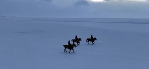 Gençler atları buz tutan Çıldır Göl'ü üzerinde dörtnala koştu