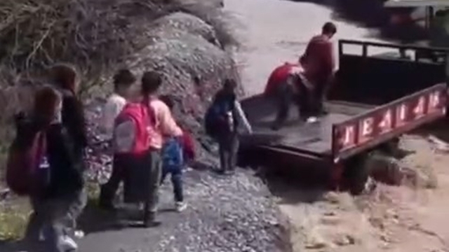 Öğrenciler, debisi yükselen dereyi traktörle geçti