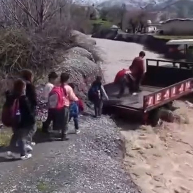 Öğrenciler, debisi yükselen dereyi traktörle geçti