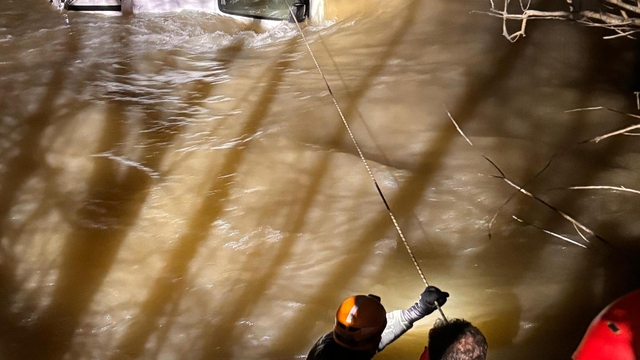 Nehre uçan araçta mahsur kalan sürücü, ekipler tarafından halatla kurtarıldı