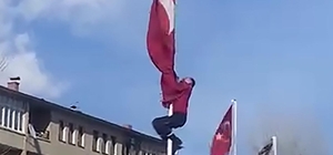 Rüzgârda dolanan bayrağı düzeltmek için 15 metrelik direğe tırmandı; o anlar görüntülendi