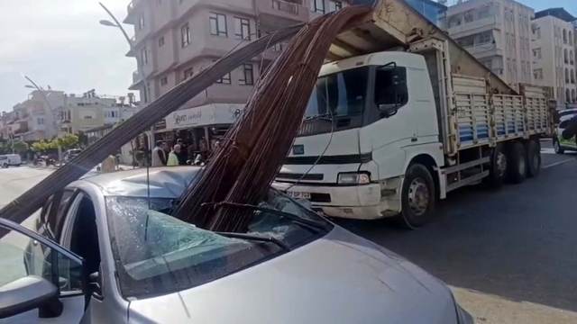 Kamyonun kasasından düşen inşaat demirleri, otomobilin tavanını deldi