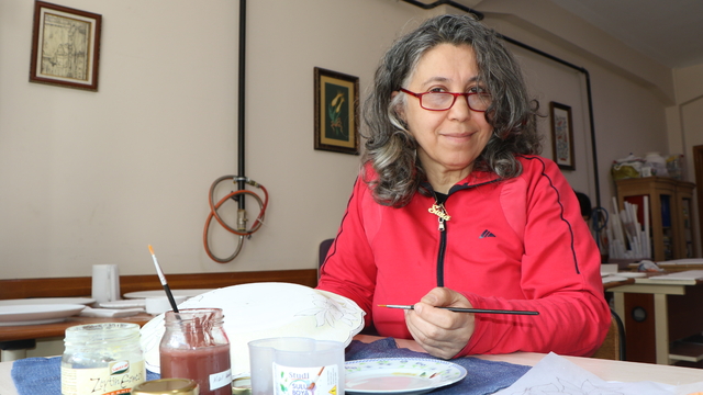 Kazanın izlerini çini fırçasıyla siliyor