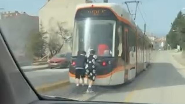 Tramvayın arkasına tutunan patenli çocukların tehlikeli yolculuğu