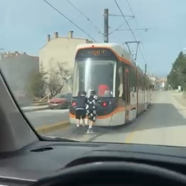 Tramvayın arkasına tutunan patenli çocukların tehlikeli yolculuğu
