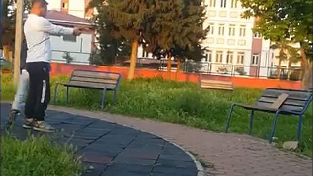 Parkta oyuncak silahla atış talimi kamerada