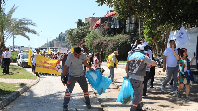 1 Mayıs kutlamalarında yürüyen işçilerle çalışan işçiler aynı karede
Belediye işçileri bayramda da işleri aksatmadı, yürüyüş güzergahında yol ve kaldırım çalışması yaptı