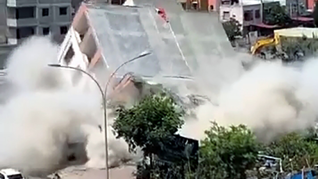 Apartmanın yıkımı sırasında, kaldırımdaki kadın enkaz altında kalmaktan son anda kurtuldu