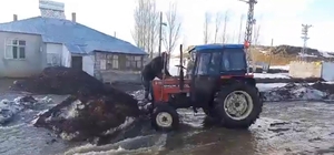 Eriyen karların sele dönüştüğü köyde traktörlerle suyun önünü açmaya çalışt...