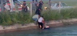 Şanlıurfa'da kanala devrilen otomobildekilere yardım için suya giren Suriye...