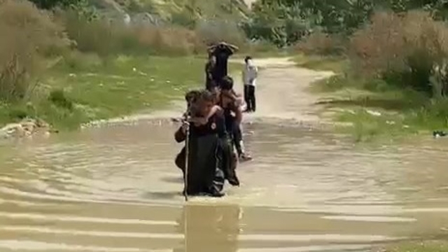 Dere kenarında mahsur kalan 5 çocuğu, itfaiyeciler sırtlarında taşıyıp kurtardı