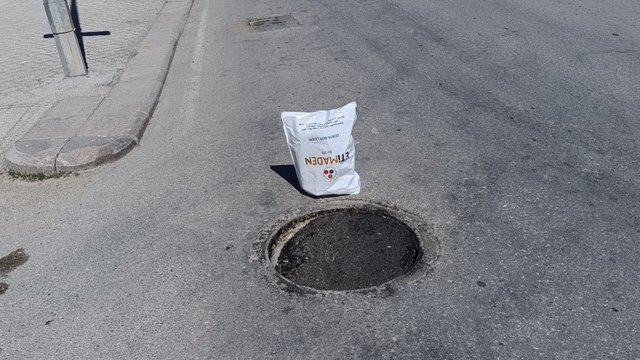 Çöken rögar kapağını gören vatandaş poşetle önlem aldı