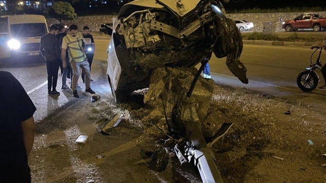 Aydınlatma direğine çarpan otomobil, beton kaidesi üzerinde asılı kaldı