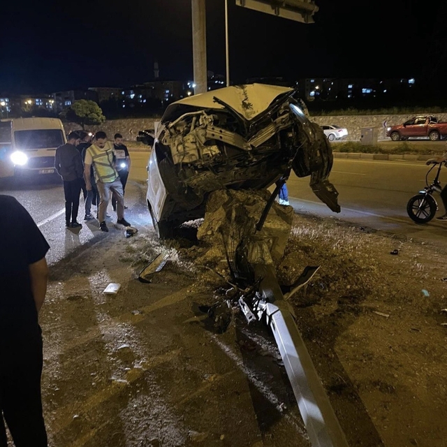 Aydınlatma direğine çarpan otomobil, beton kaidesi üzerinde asılı kaldı