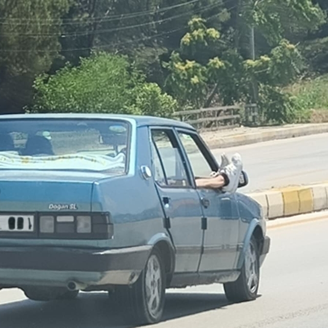 Ayaklarını camdan dışarı çıkartan yolcu trafiği riske attı