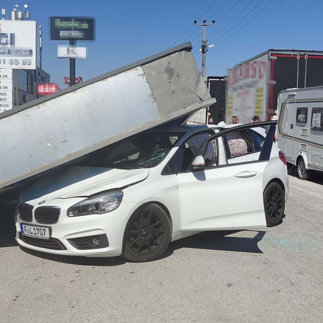 Üzerine reklam totemi devrilen otomobilin sürücüsü yara almadan kurtuldu