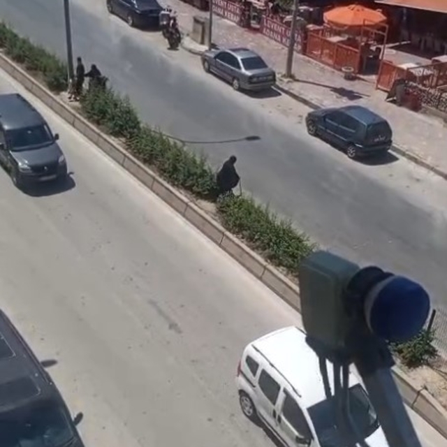 Elinde bastonuyla refüje çıkarak yolun karşısına geçmeye çalışan yaşlı kadı...