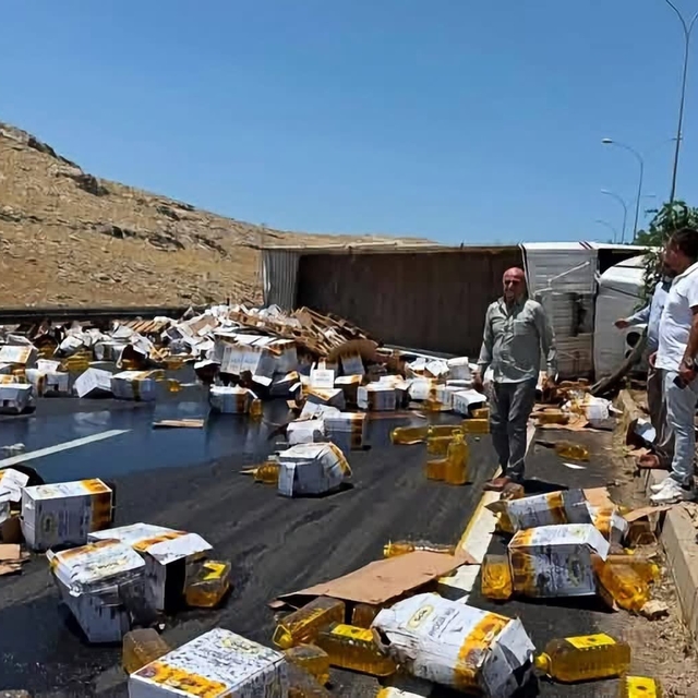Devrilen tırdaki yağ bidonları yola savruldu