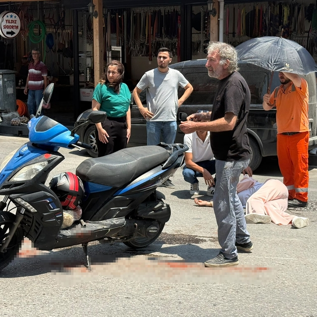 Kazada yaralanan genç kadına esnaftan şemsiyeli destek