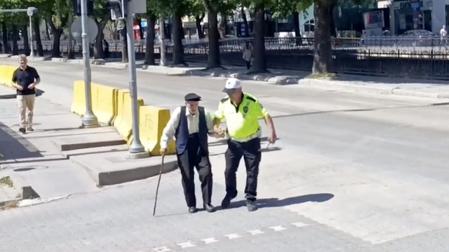 Trafik polisinin yürümekte zorlanan yaşlı adama yardımı yürekleri ısıttı