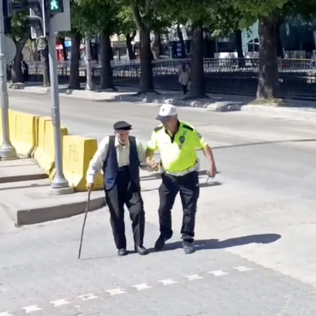 Trafik polisinin yürümekte zorlanan yaşlı adama yardımı yürekleri ısıttı