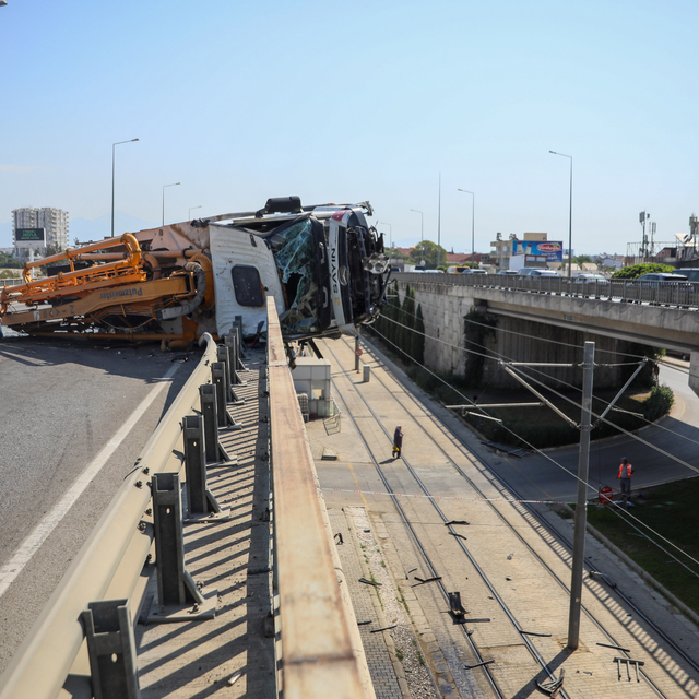 Yan yatan beton pompası kamyonu, üst geçitte asılı kaldı