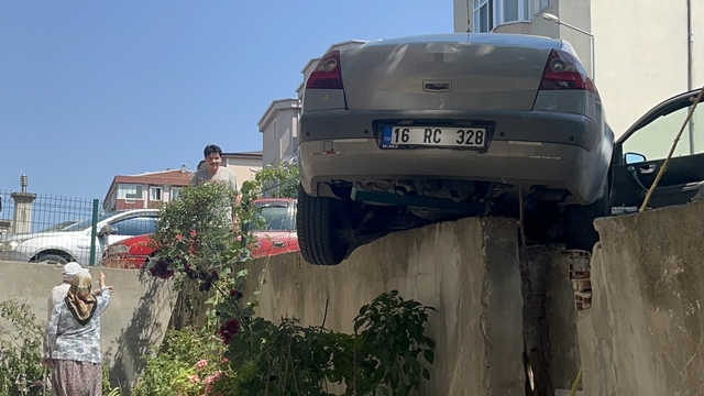 El frenini çekmeyi unuttu, otomobil bahçe duvarında asılı kaldı