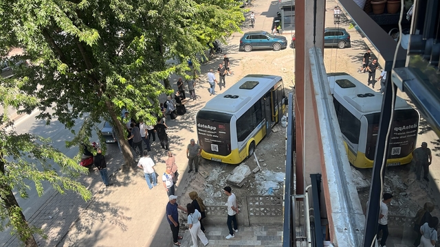 Kaldırıma çıkıp iş yerine çarpan minibüs, boş arsaya girdi