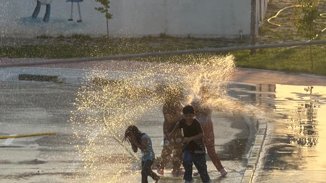 Iğdır'da çocuklar hortumdan akan suyla oynayıp serinledi
