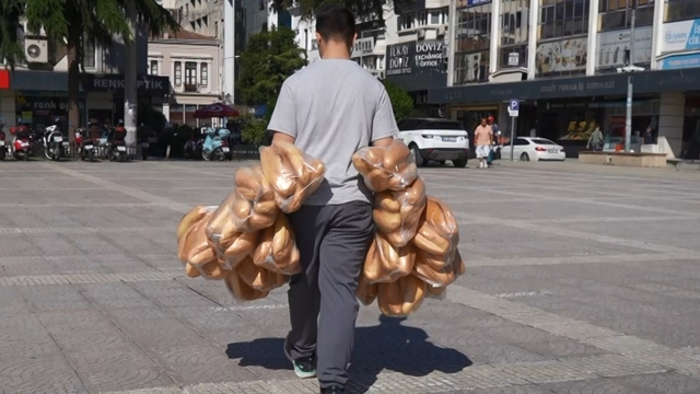 Elinde 100 ekmek taşıyan garson görenleri şaşırtıyor
Atakan'ın ekmek mücadelesi: Onlarca poşet, 100 ekmek
Gören dönüp bir daha bakıyor