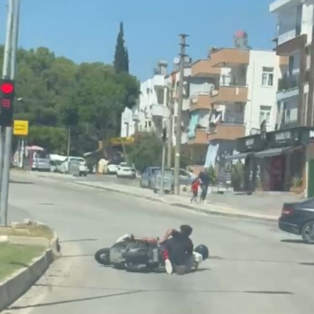Tehlikeli hareketlerle motosikleti süren sürücü ve arkasındaki yolcunun düş...