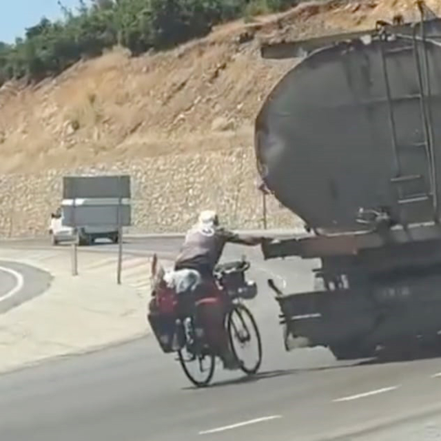 Tankere tutunup yolculuk yapan bisikletli kamerada