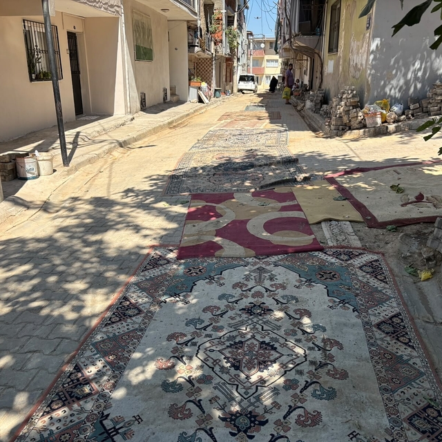 Mahalleli tozdan korunmak için onarılmayan yollara halı serdi