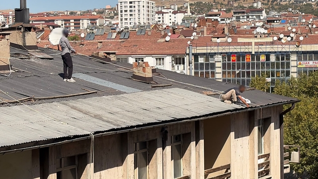 Çatıda oluk temizliği yapan şahıs, beline halat bağlayarak güvenlik önlemi aldı