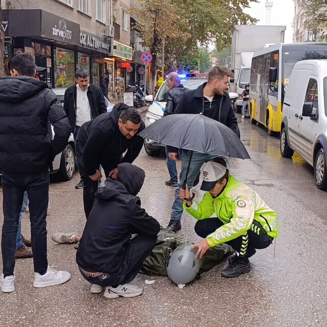 Kadın polis, yaralı ıslanmasın diye başında şemsiyeyle bekledi