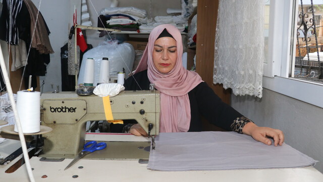 Kadın muhtar mahallelinin hem derdini dinliyor hem terziliğini yapıyor